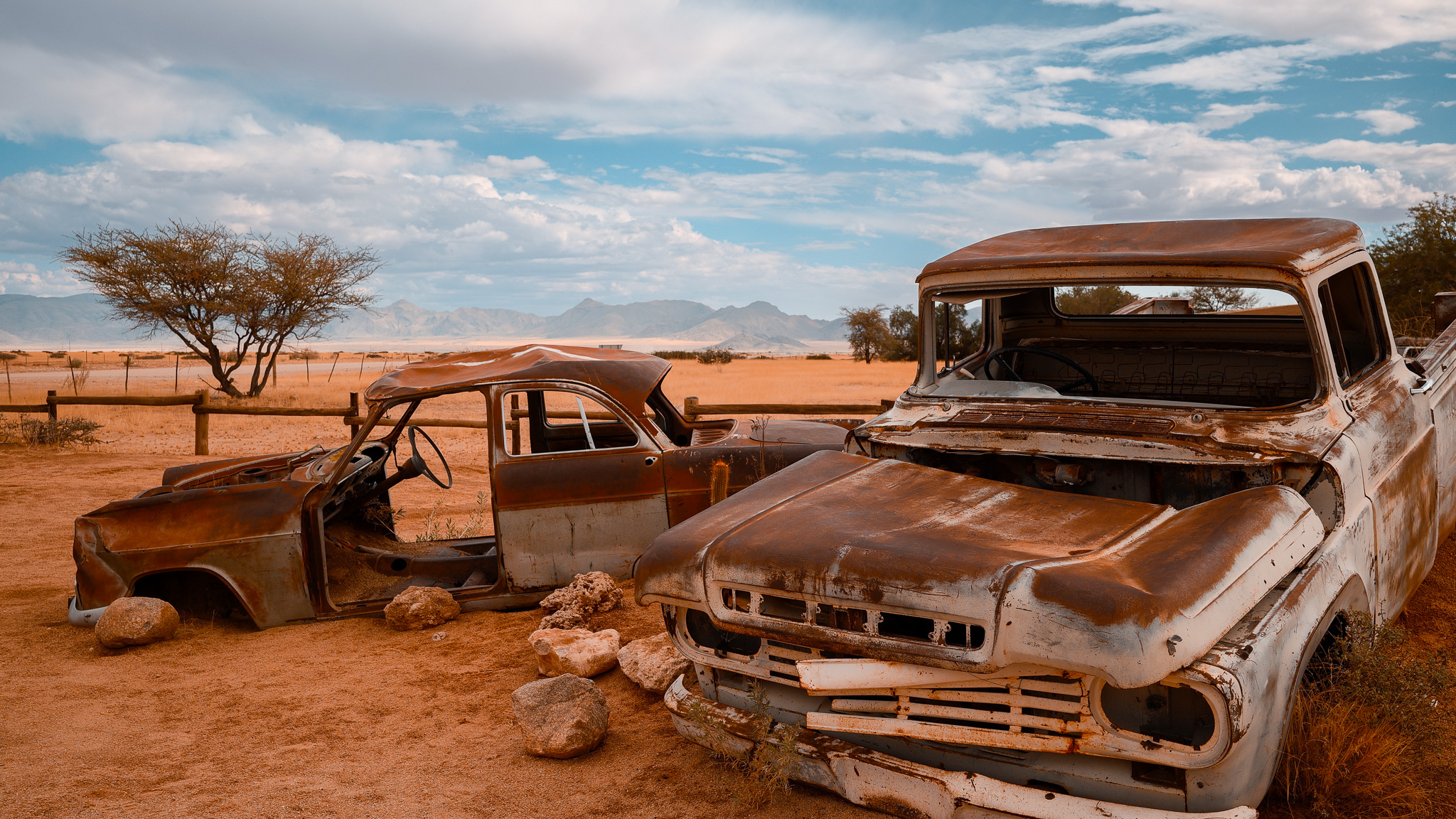 Die berühmten rostigen Autowracks von Solitaire vor der Namib-Landschaft